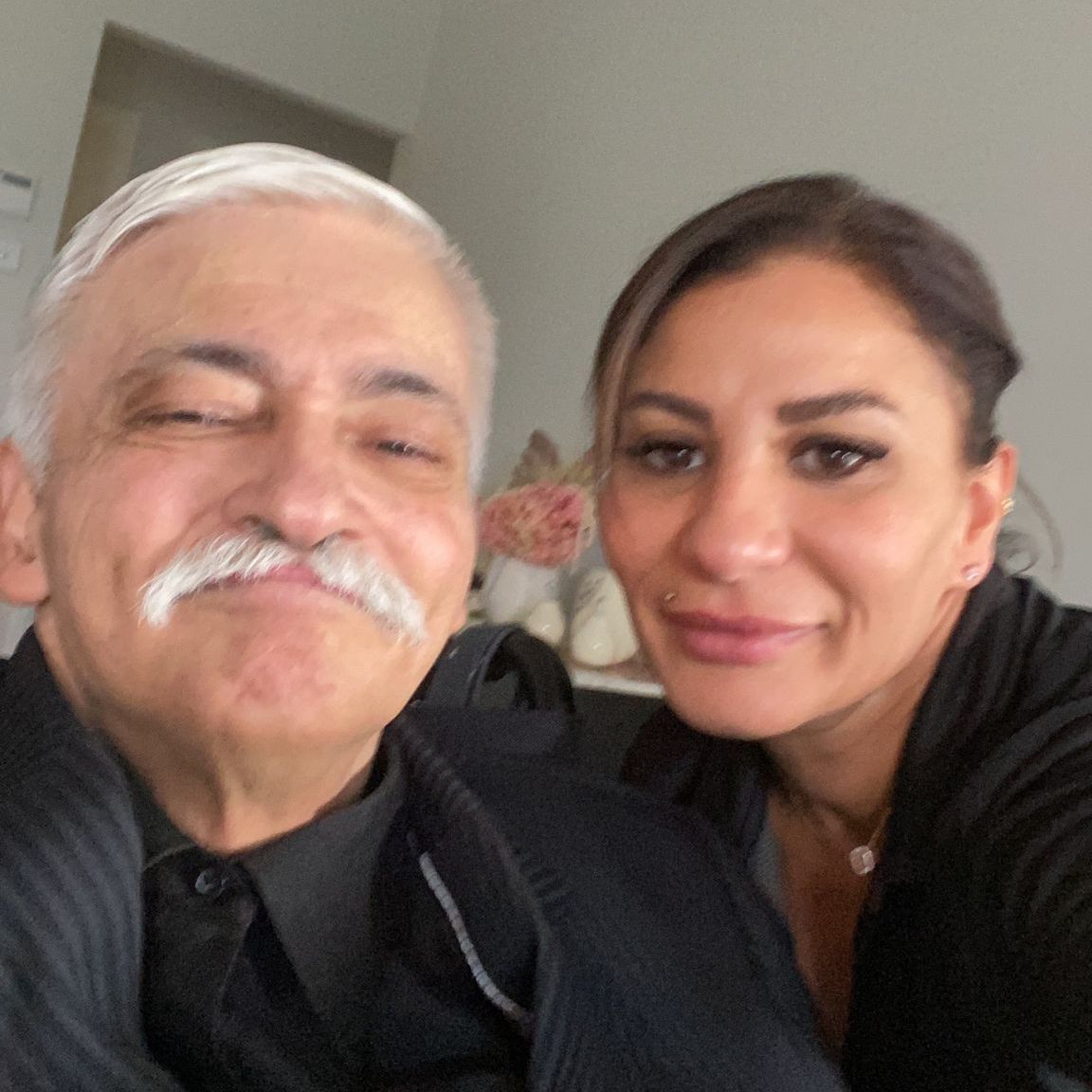 A man with a mustache is posing for a picture with a woman