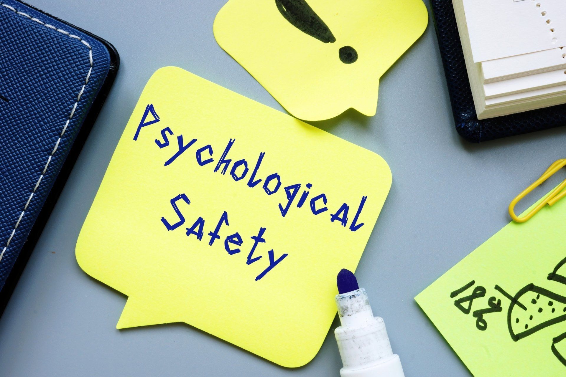 A yellow sticky note with the words psychological safety written on it