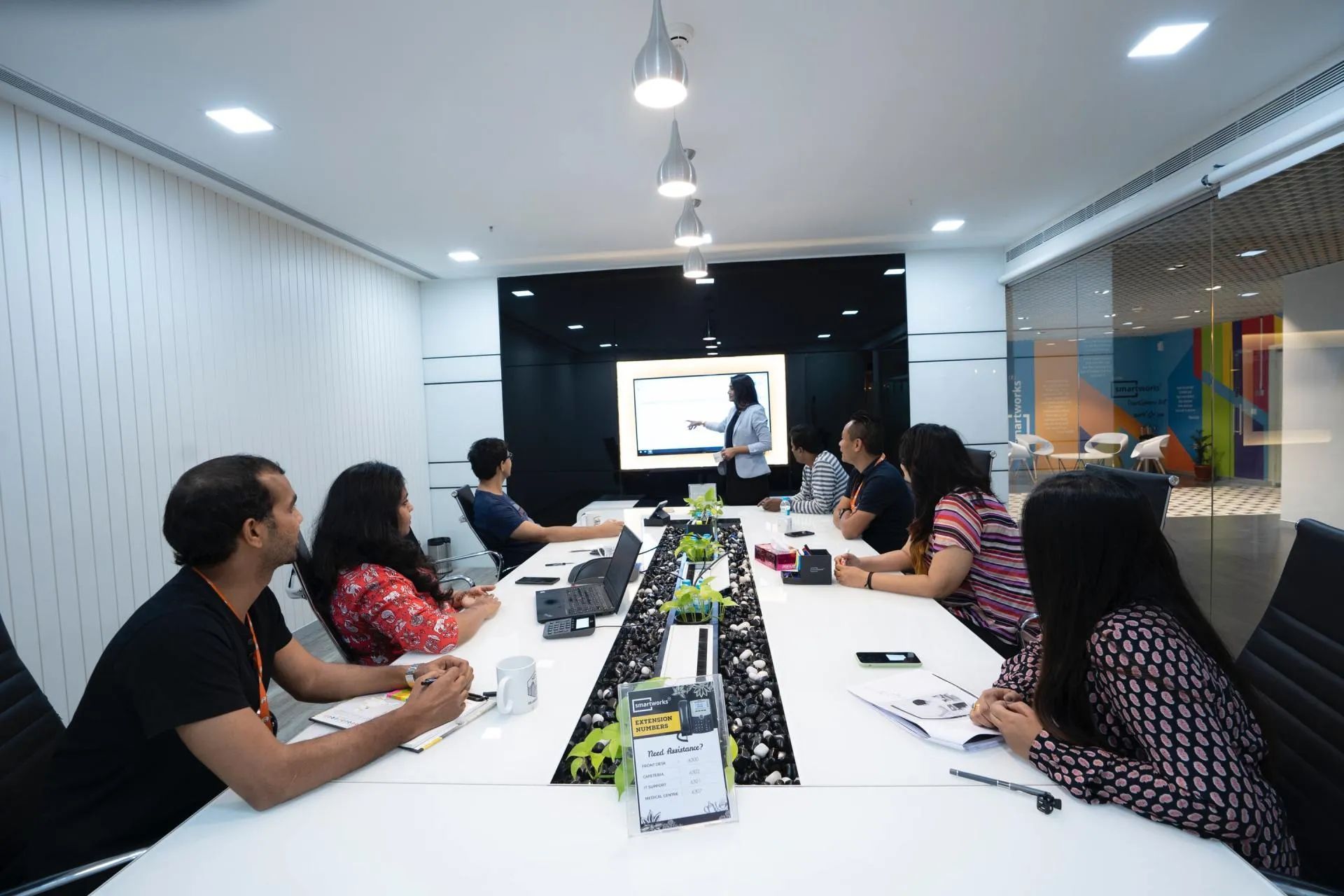A group of people are sitting around a long table in a conference room.