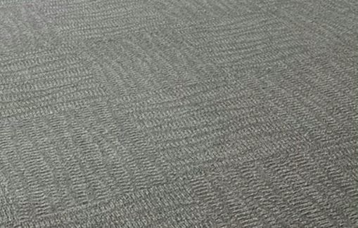 A close up of a gray carpet with a herringbone pattern.