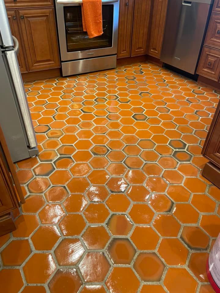 A kitchen with a honeycomb tile floor and stainless steel appliances.