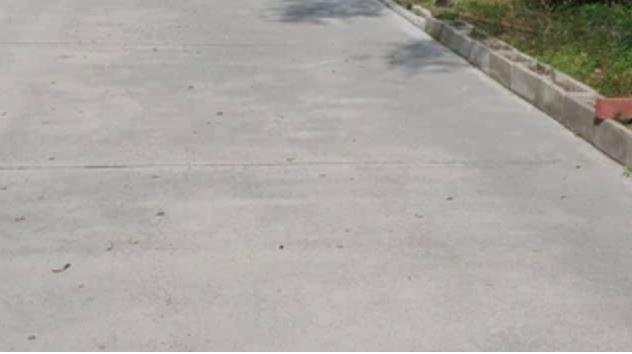 A concrete road with a red curb on the side of it.
