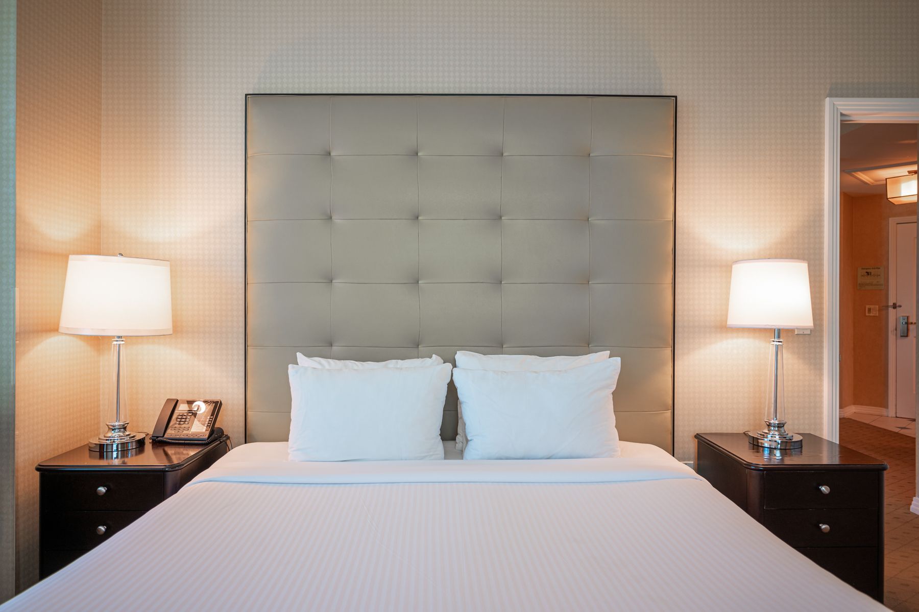 Symmetrical bedroom with a large bed, tufted headboard, and matching bedside lamps on both sides