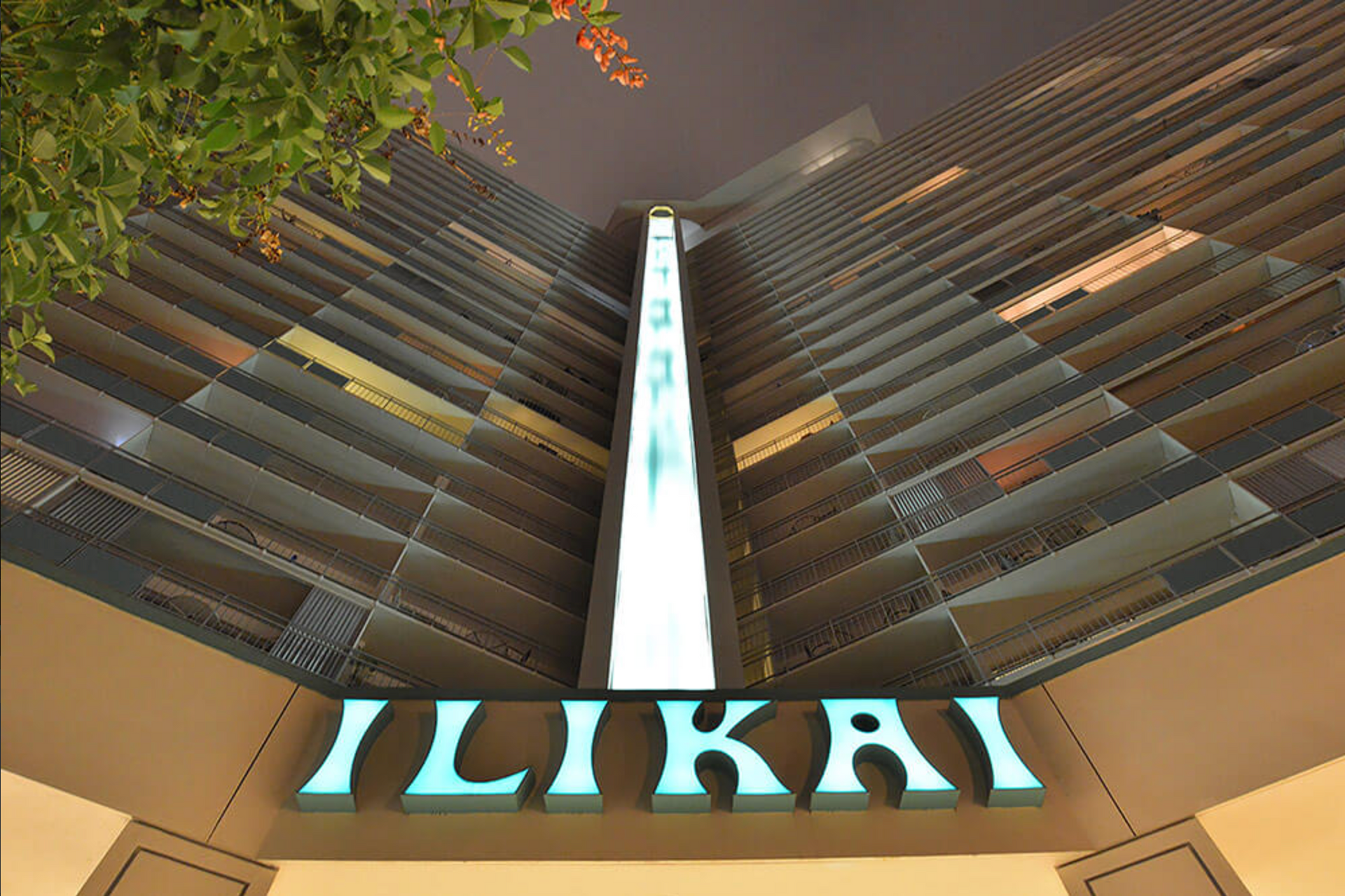 Interior view of the ZIKAI atrium with curved balconies and a central illuminated sign