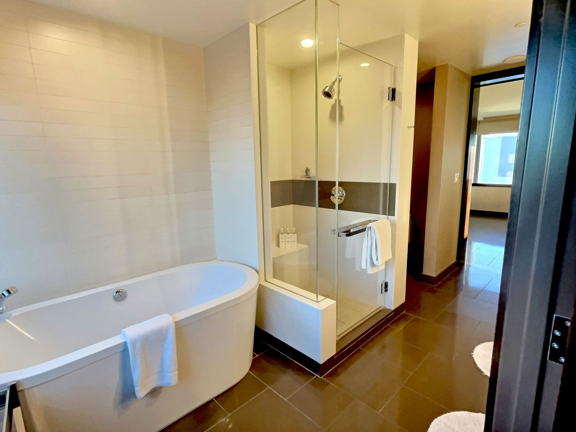 Modern bathroom with freestanding tub, glass shower, and tiled floor