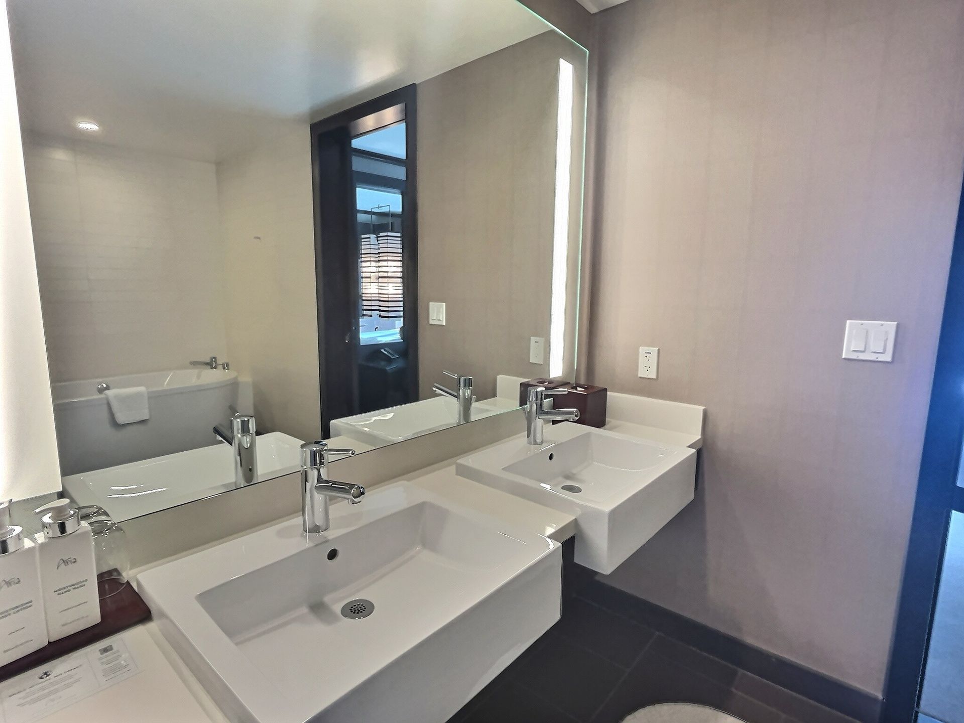 Modern bathroom with double sinks, large mirror, and neutral gray walls