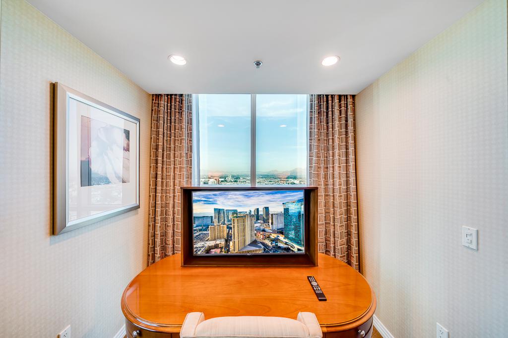 Small dining nook with wooden table, city-view window, and curtains