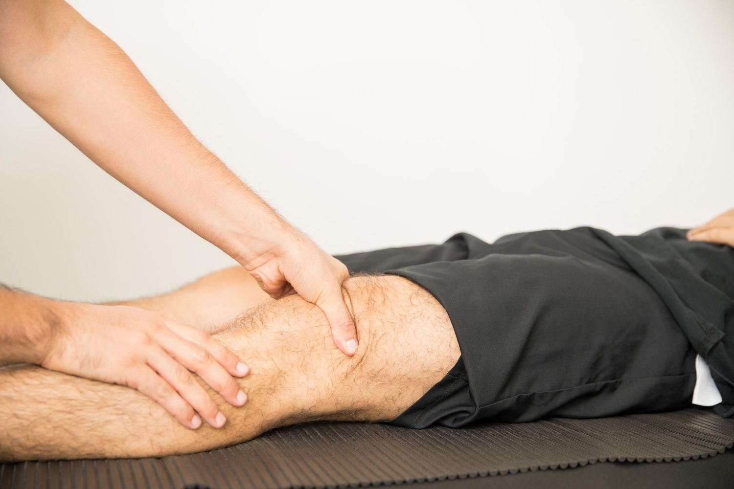 Hands massaging a person’s leg on a treatment table in a spa or physical therapy setting