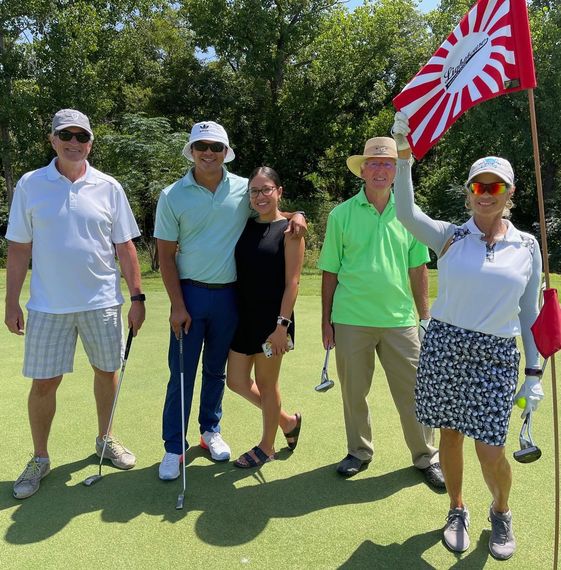 A group of people posing for a picture on a golf course