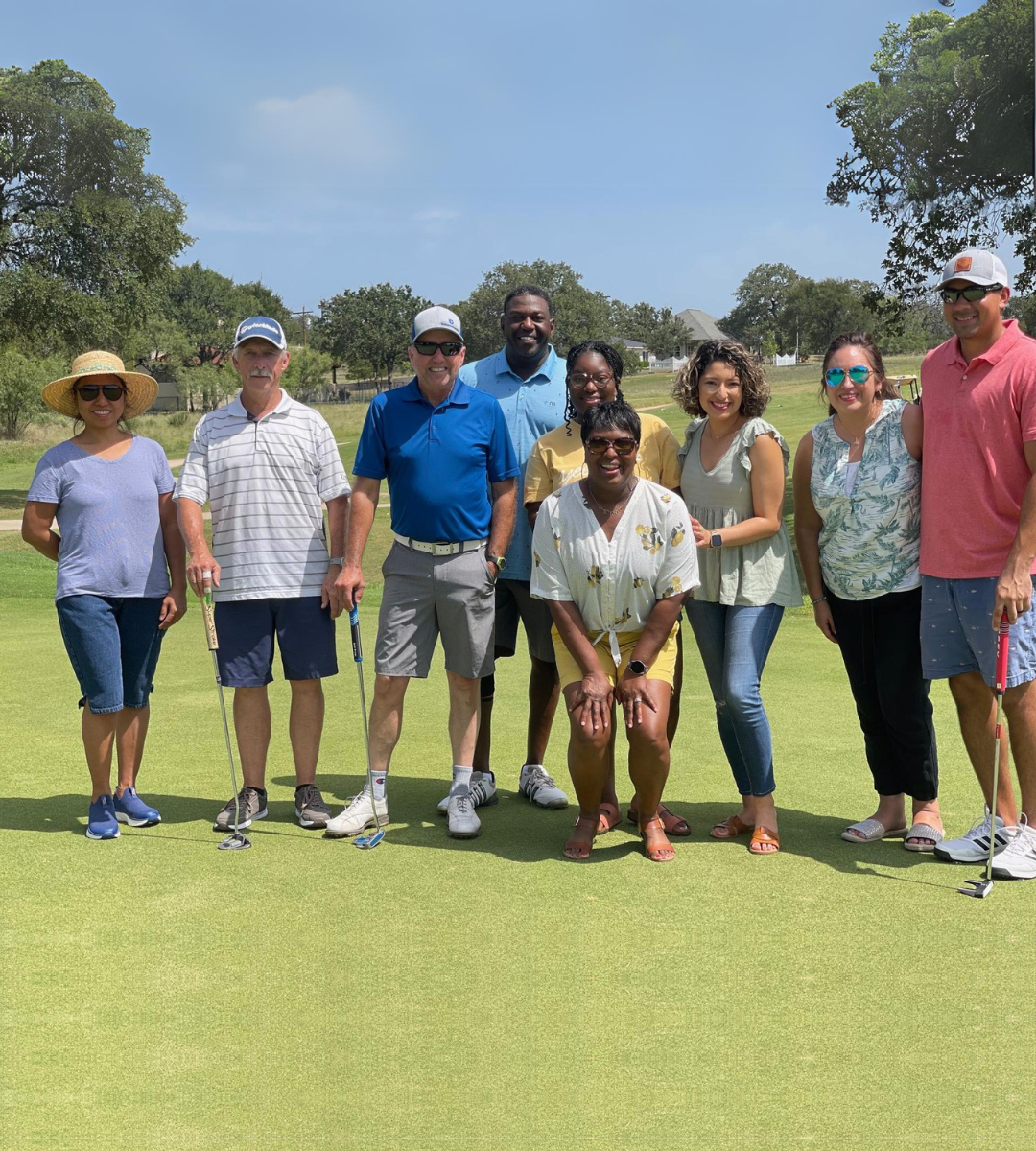 A group of people are posing for a picture on a golf course.