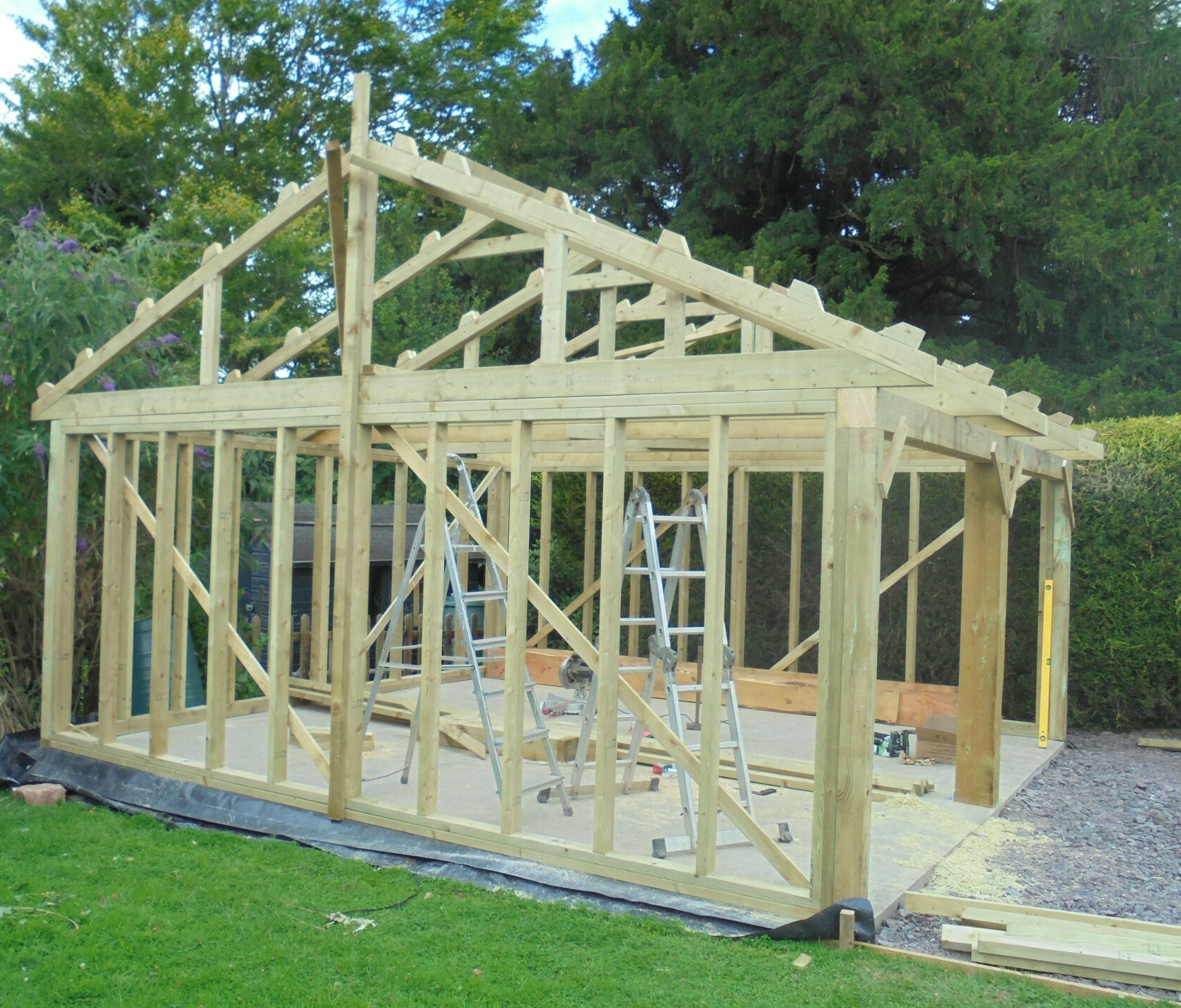 A wooden structure is being built in a backyard