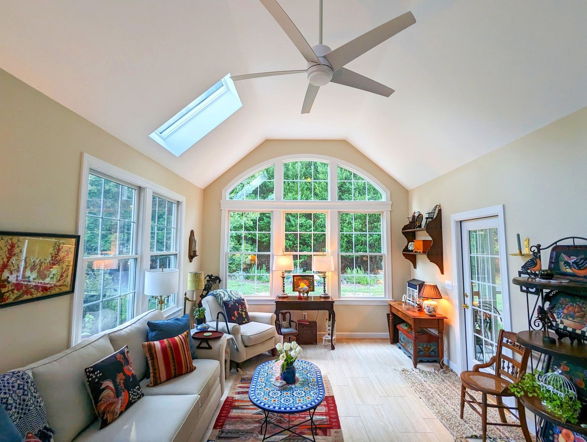 A living room with a vaulted ceiling and a ceiling fan.
