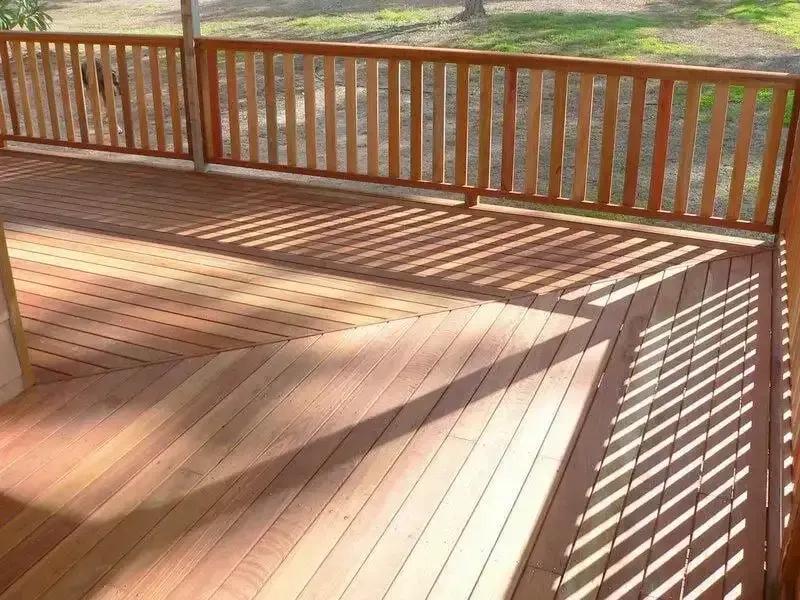 Wooden Deck With a Wooden Railing and Shadows on It — Payless Timbers in Tablelands, QLD