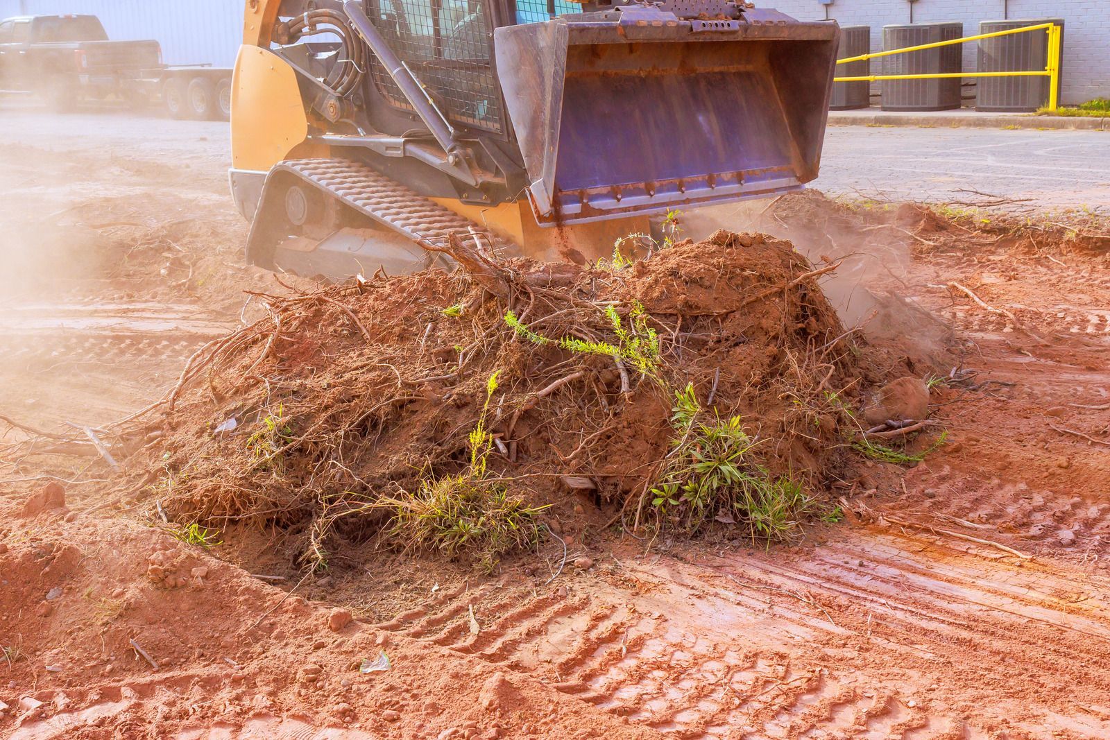 Wet concrete pouring from a truck chute onto a construction site, forming a gravelly slab surface