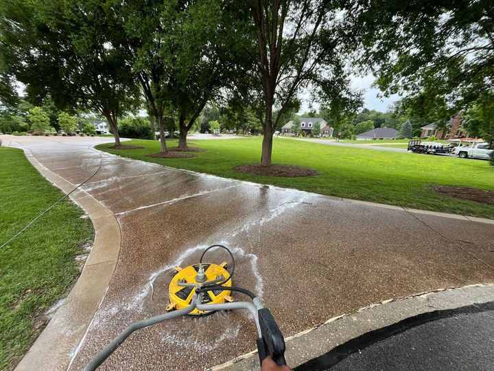 Wet concrete path with a pressure washer cleaning a sidewalk in a park.