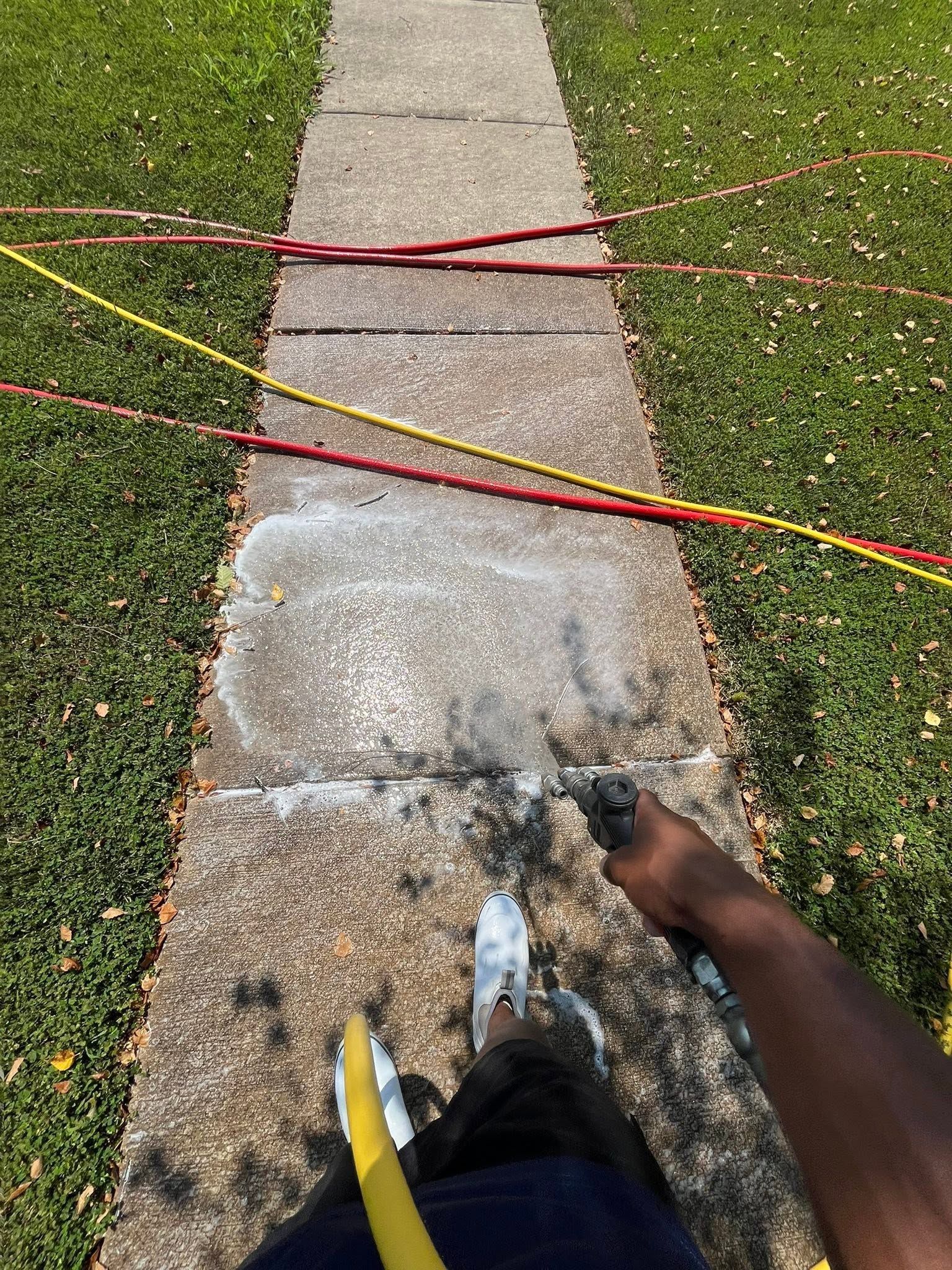 Person stepping along a sidewalk blocked by red and yellow caution tape.