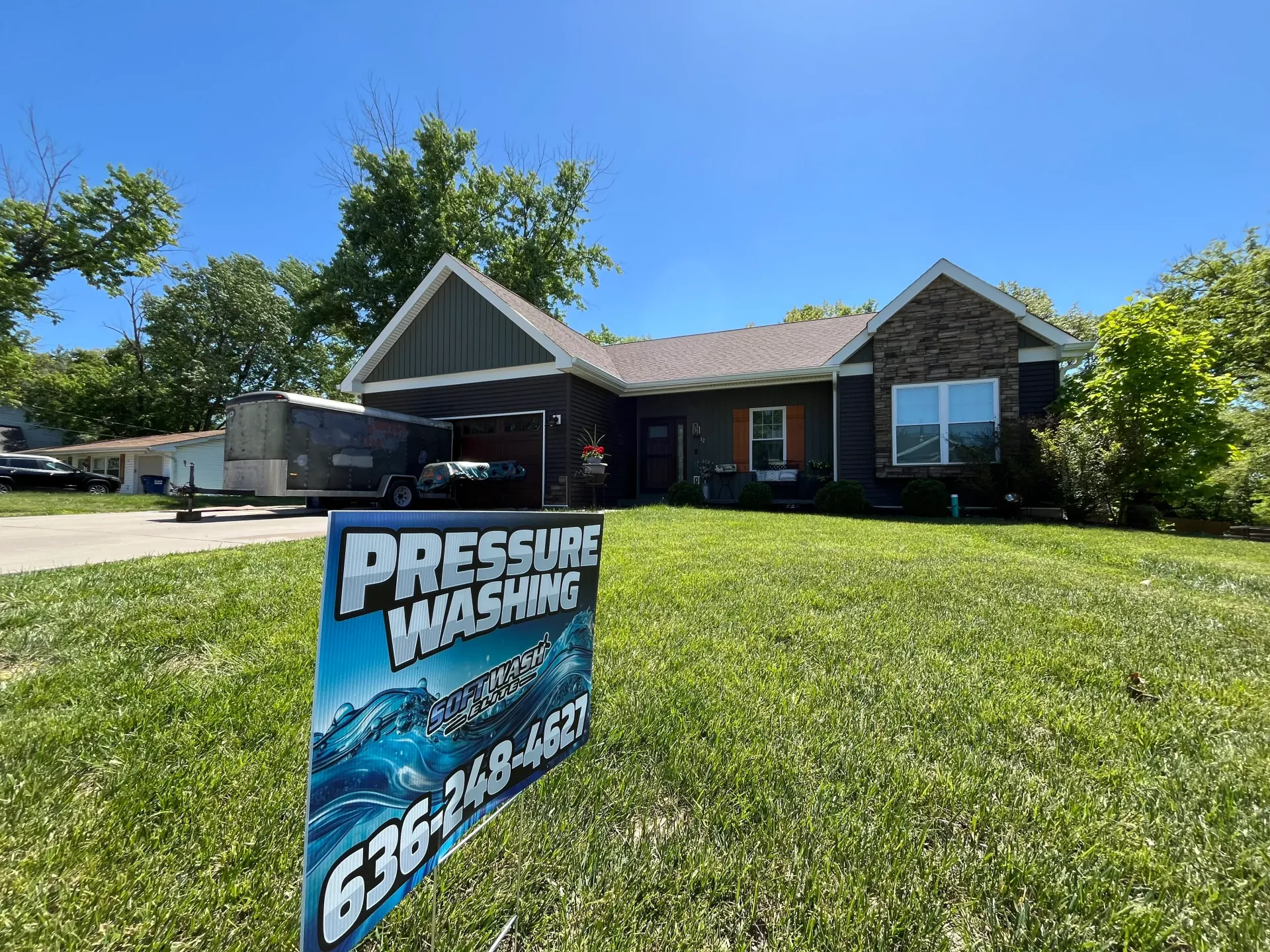 House with a blue lawn sign reading “Pest Control” on a sunny suburban street