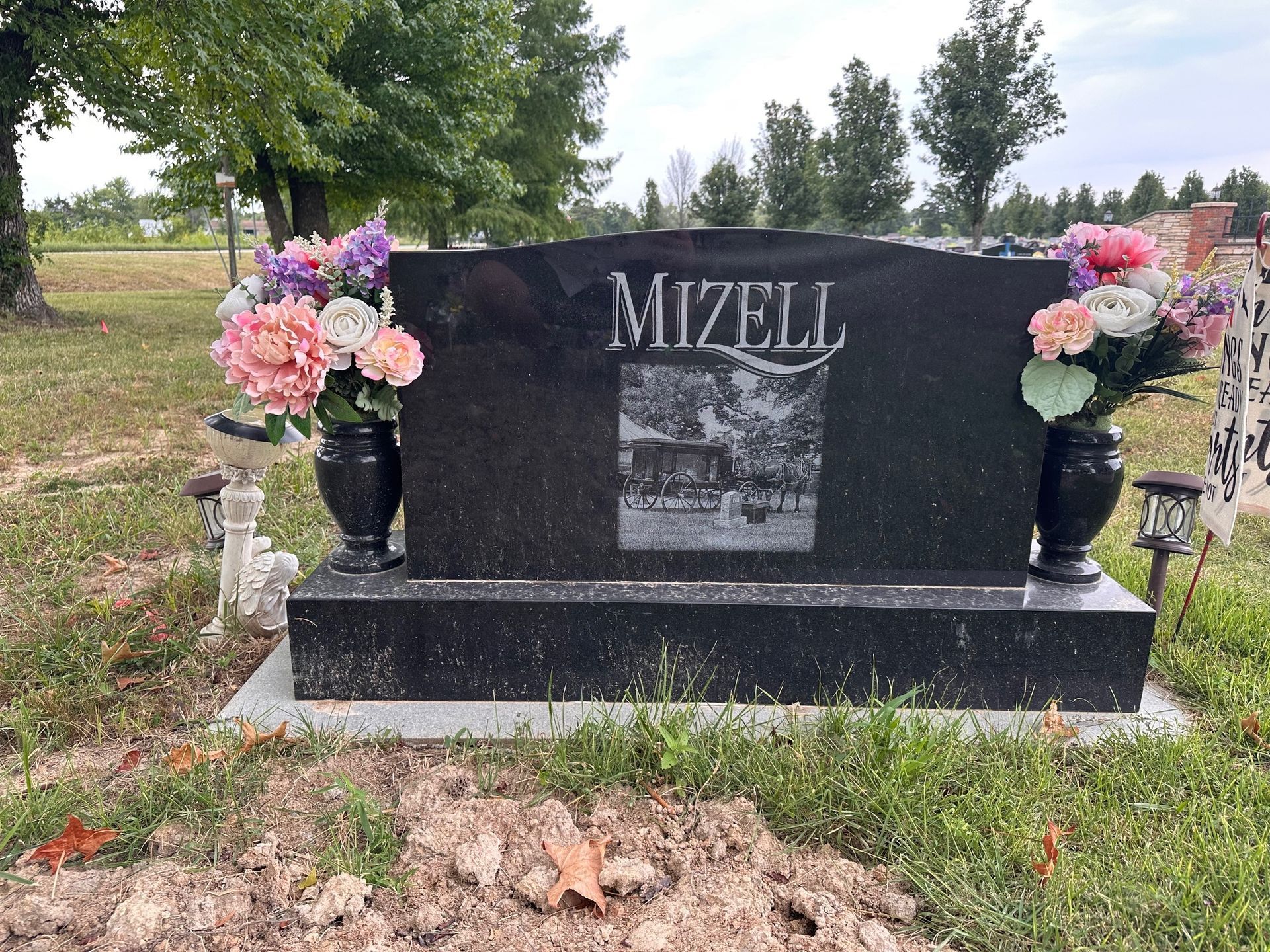 Black granite headstone in a cemetery with the name