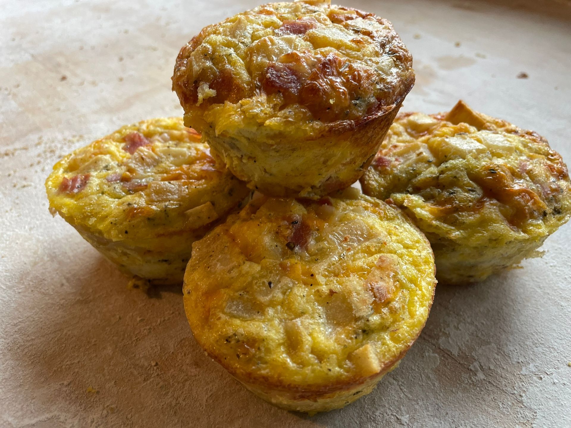 Four muffins are stacked on top of each other on a table.