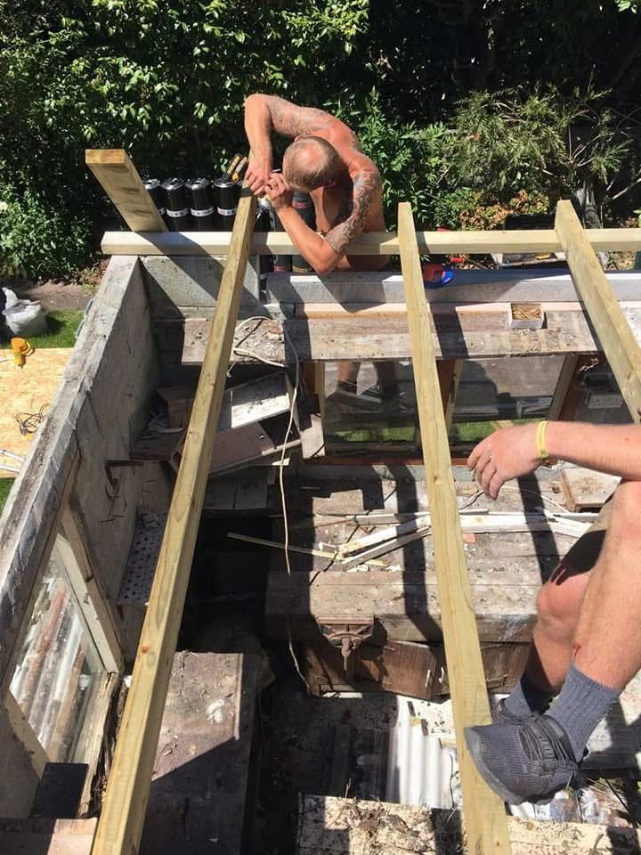 Worker installing timber roof framing during a roofing project