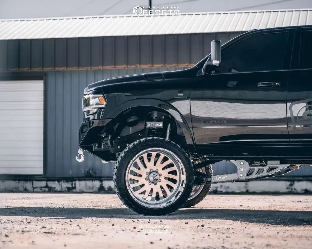 Black truck with large chrome wheels parked in front of a building.