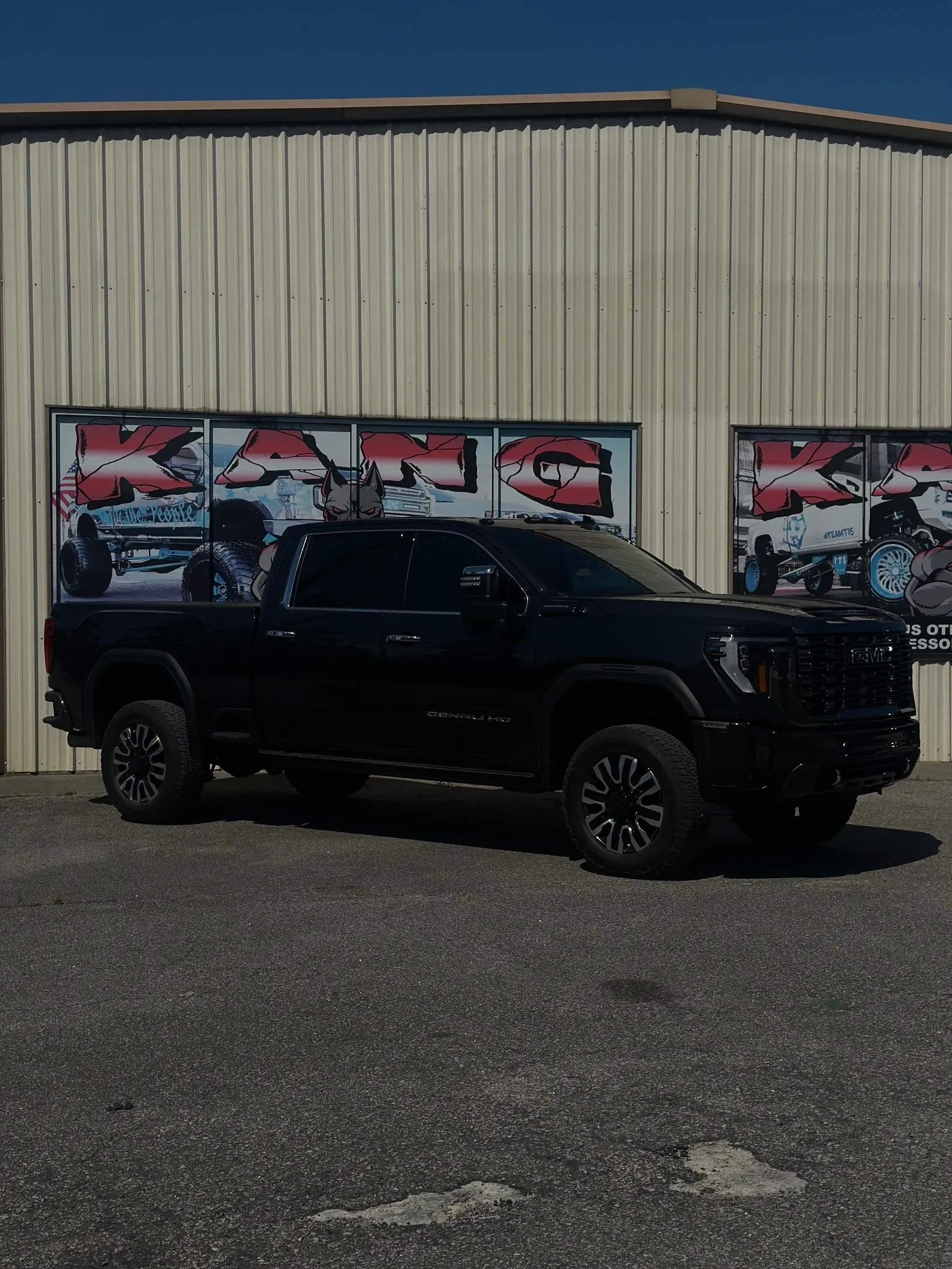 Black truck parked in front of a building with a sign that says 
