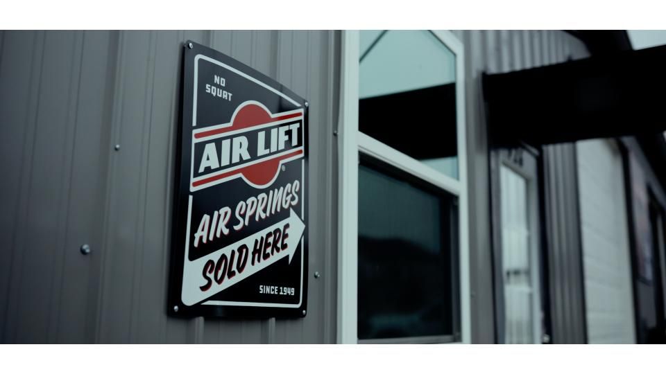 Sign on a metal building advertising air lift springs sold here.