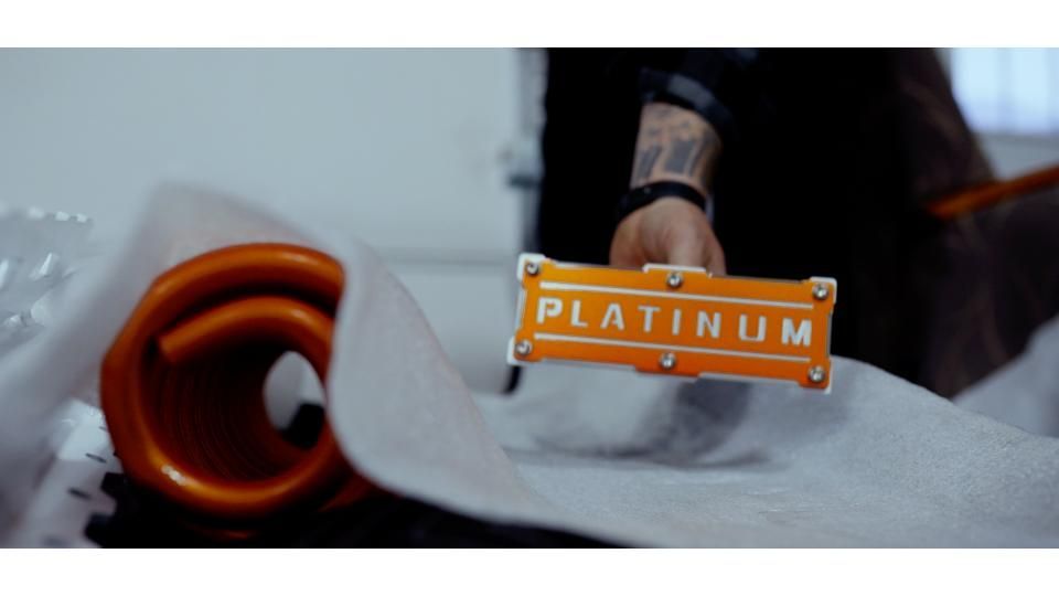 Orange razor blade package labeled “PLATINUM” beside shaving supplies on a white cloth