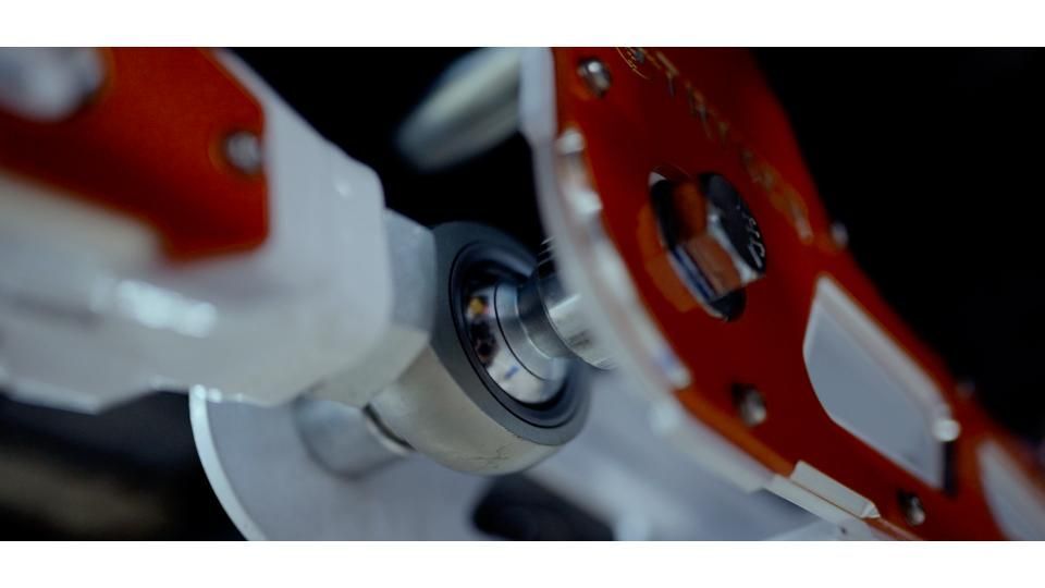 Close-up of red and white mechanical parts with a metallic bearing in the center