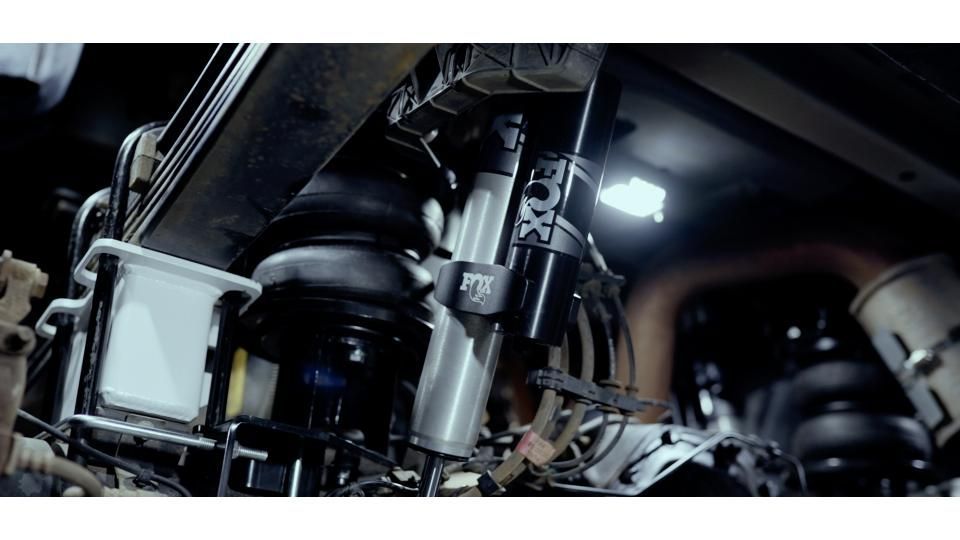 Close-up of black and silver mechanical equipment with wiring and lights inside an industrial machine