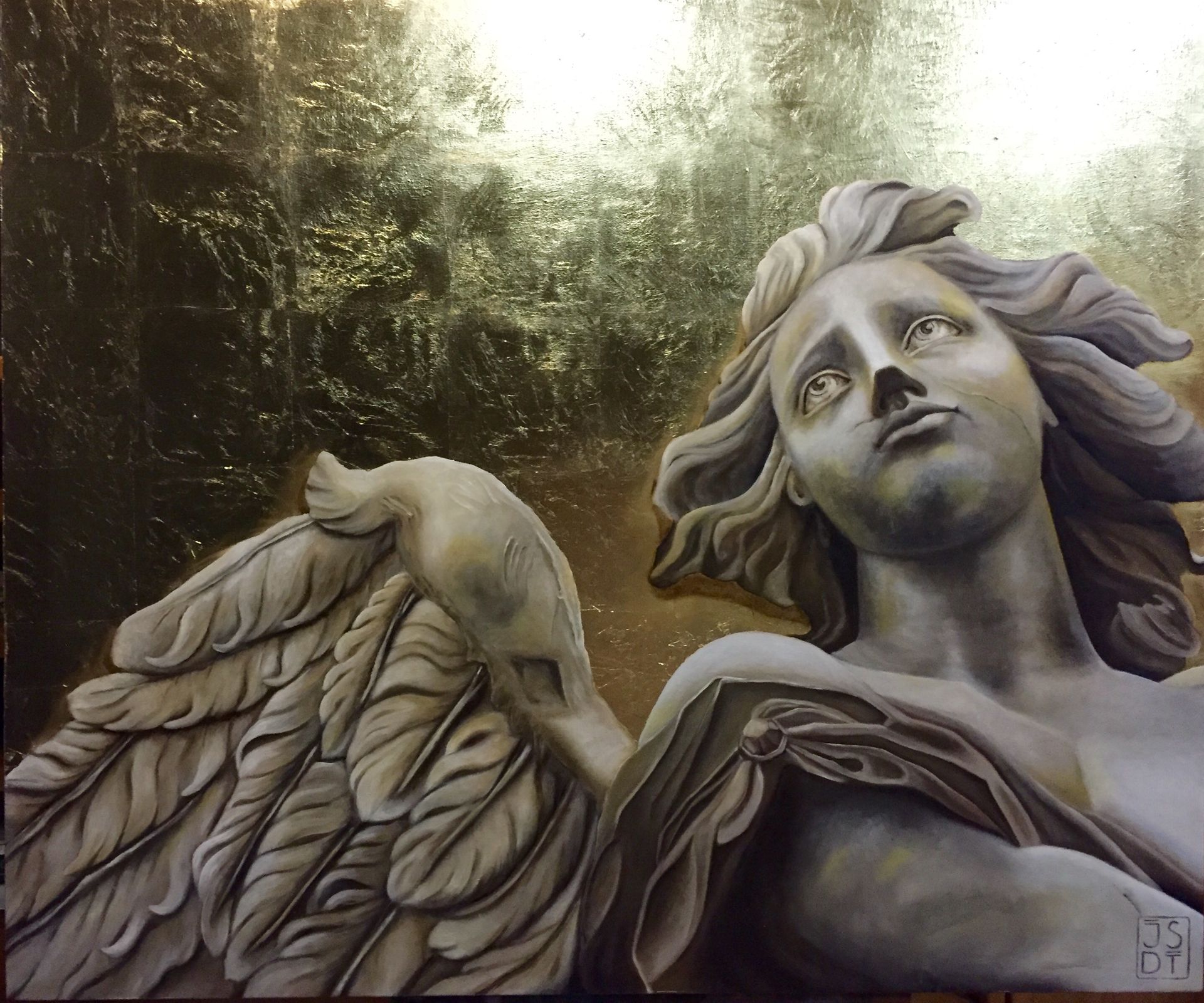 Ángel de piedra con el ala levantada y el rostro vuelto hacia arriba, sobre un fondo oscuro y frondoso.