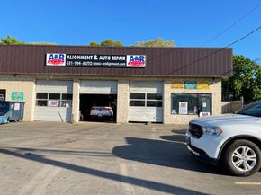A & R Auto Repair shop with a white SUV parked in front; a car is inside.  | A & R Auto Repair