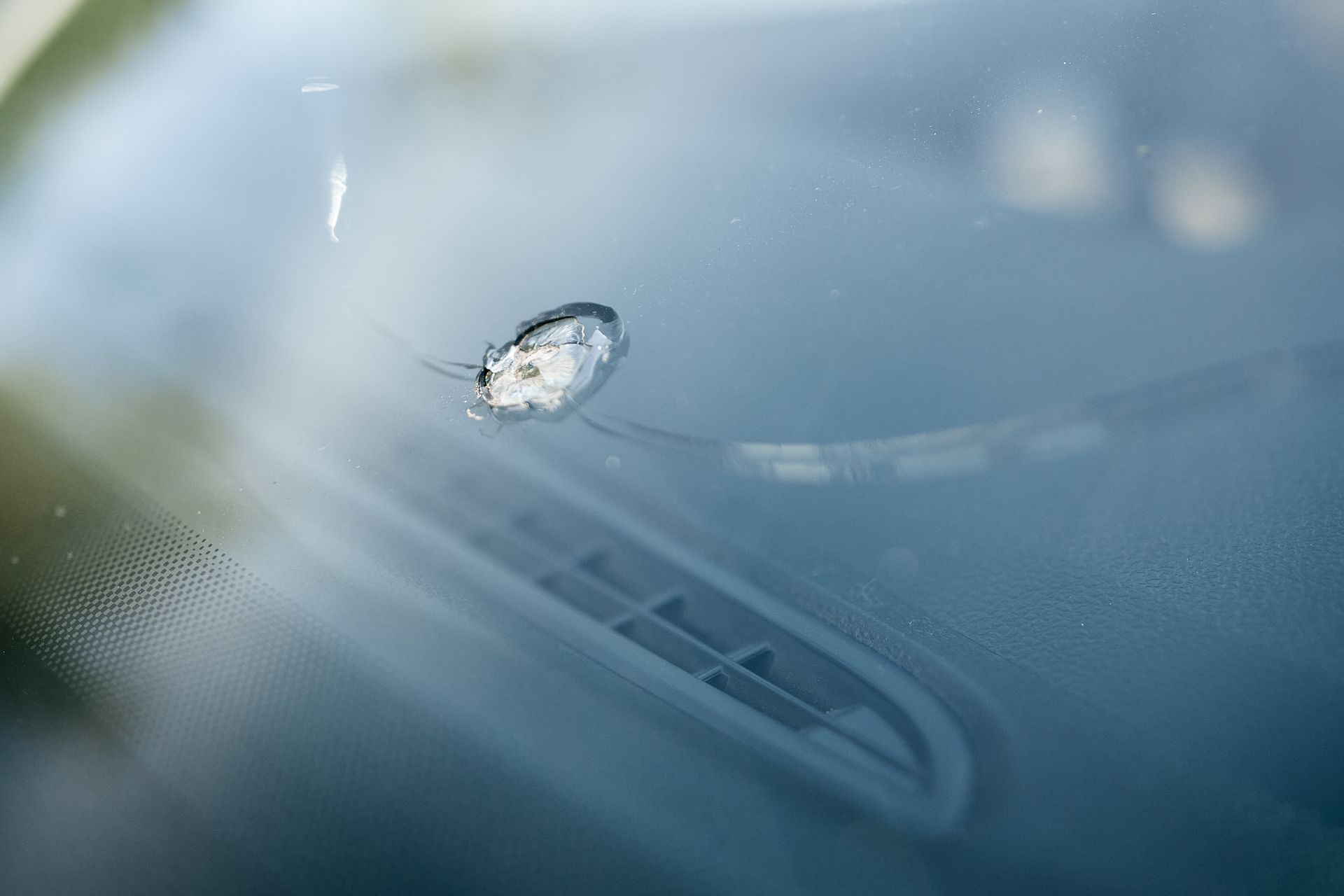 Un gros plan d'un pare-brise fissuré sur une voiture.