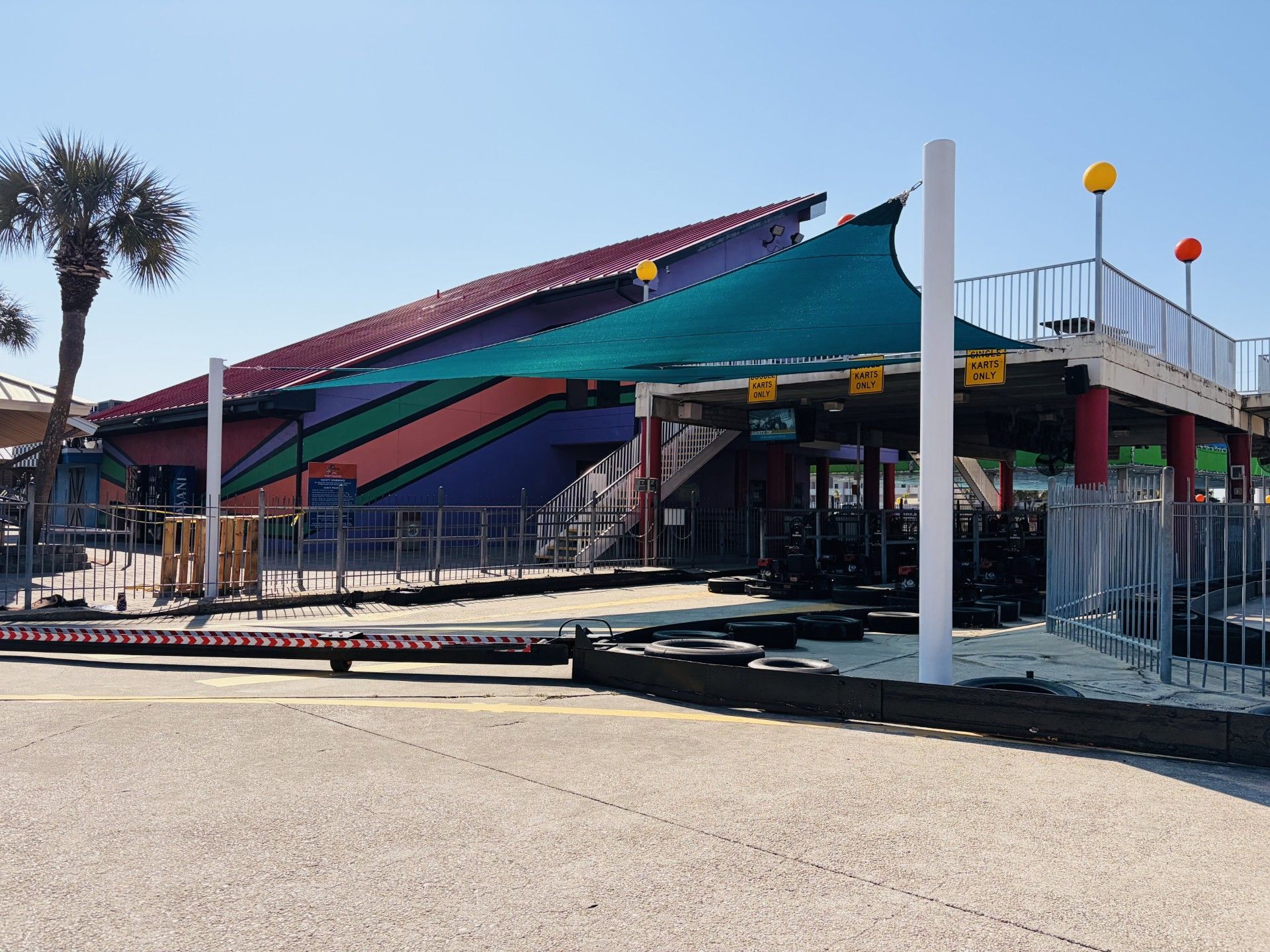 Colorful awning over a fenced entrance area on a sunny street corner