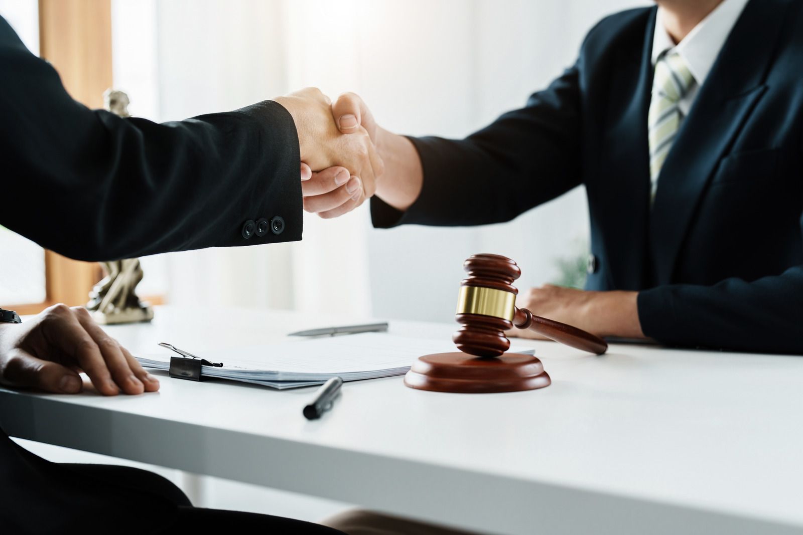 Lawyer typing on a laptop beside a gavel and scales of justice on a desk