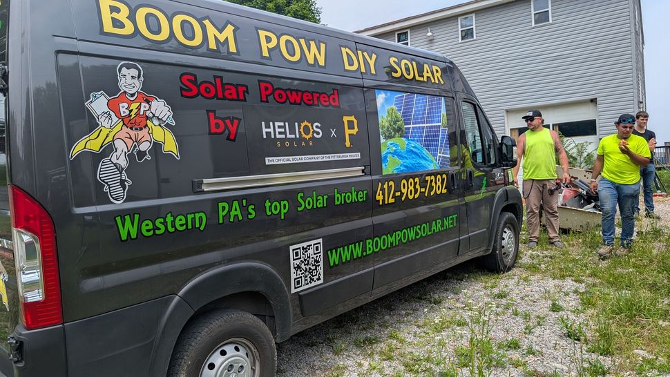 A black van is parked in front of a house.