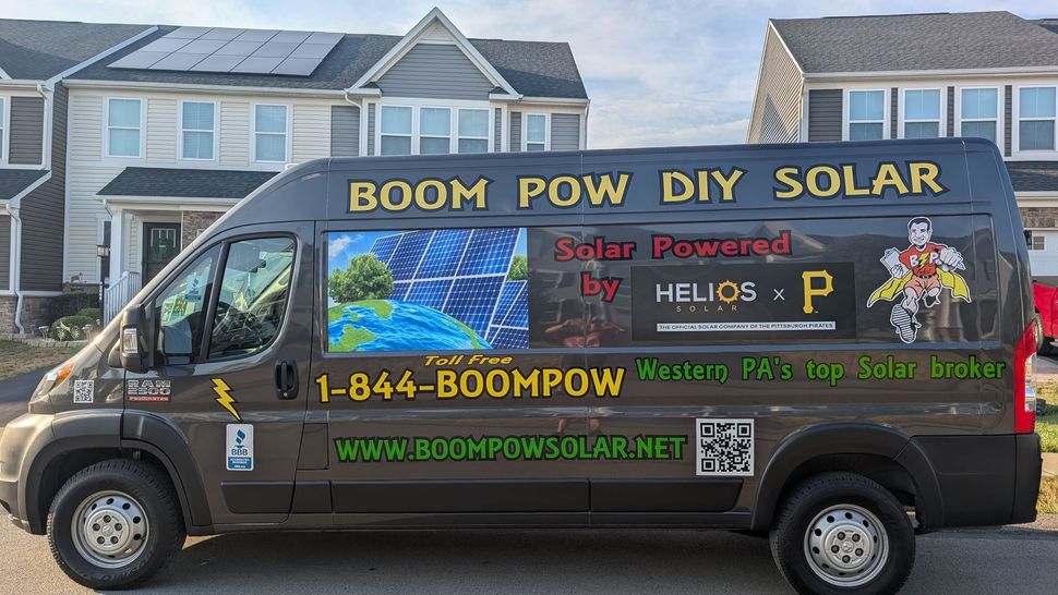 A boom pow diy solar van is parked in front of a house.