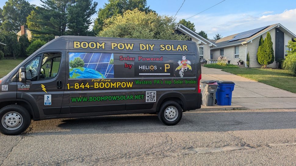A van is parked in a driveway in front of a house.