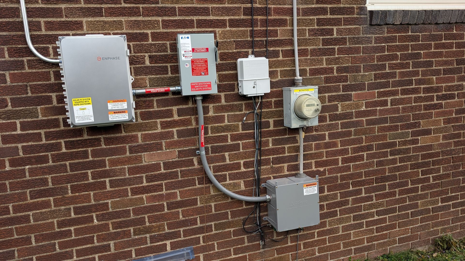 Electrical panel boxes and meter on a brick wall