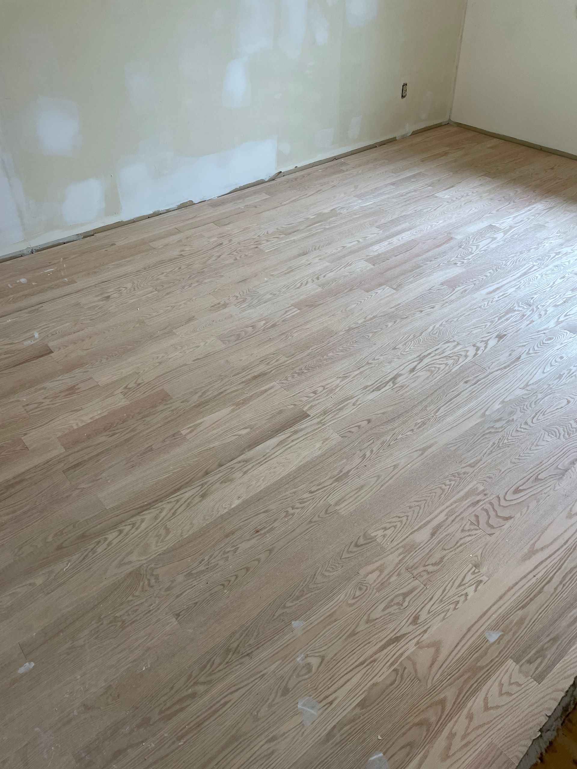 A room with a wooden floor and white walls.