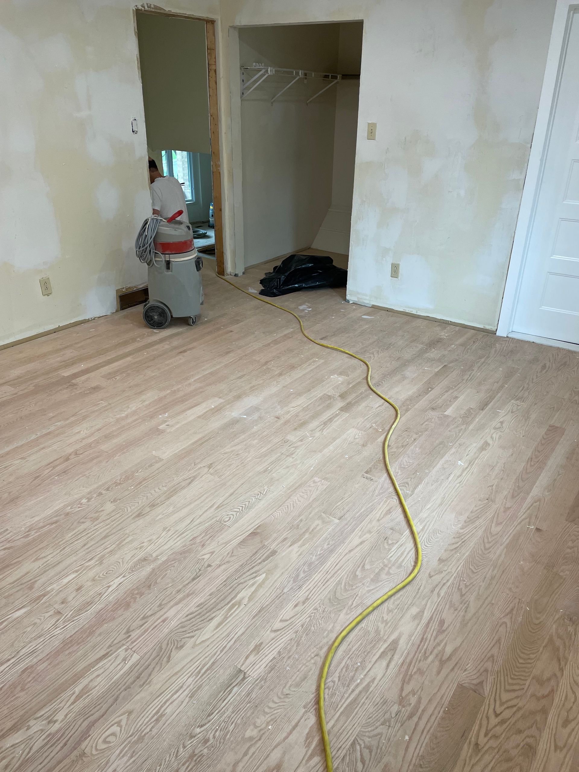 A room with hardwood floors and a vacuum cleaner in it.