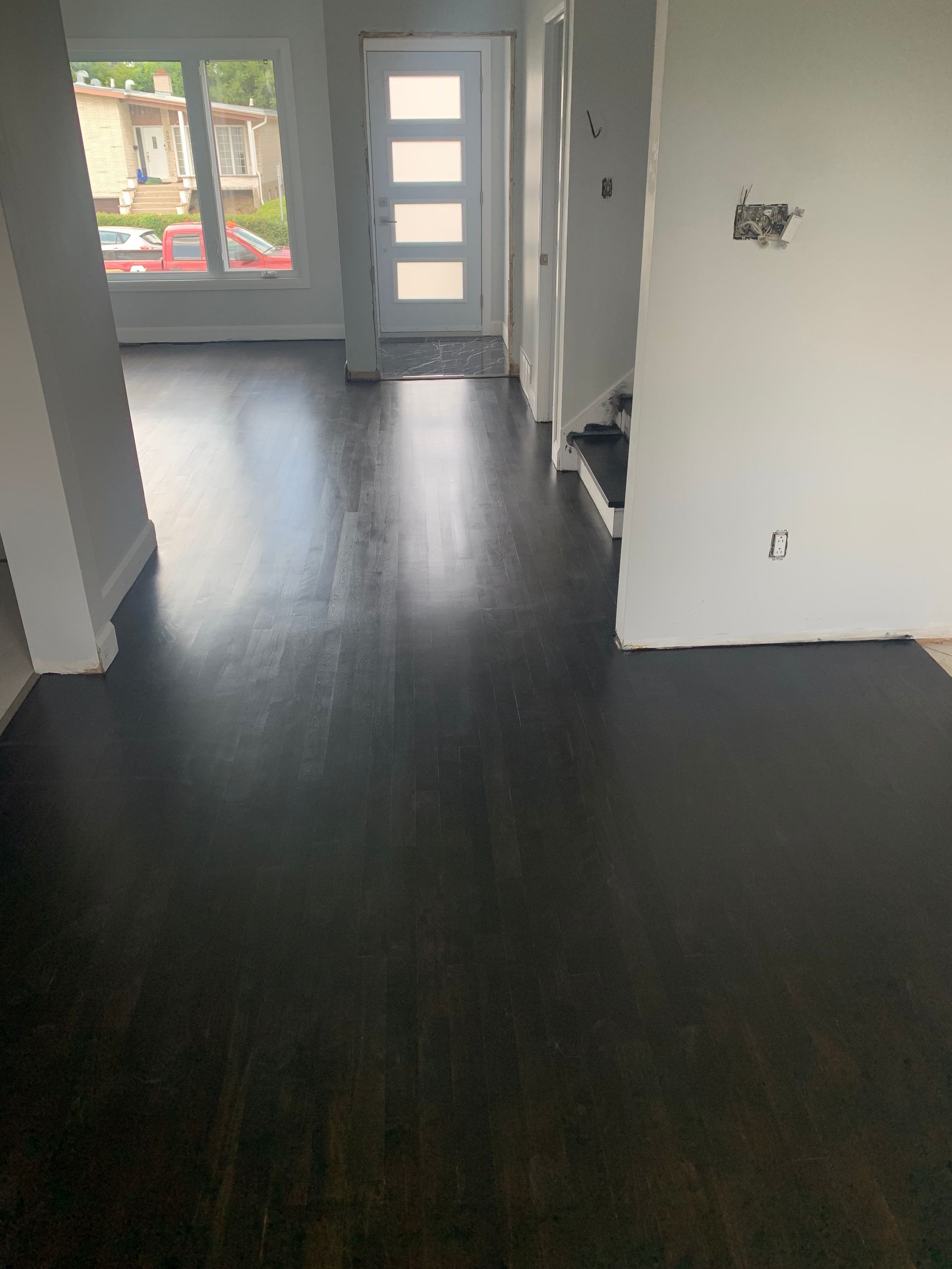 A living room with a black floor and white walls.