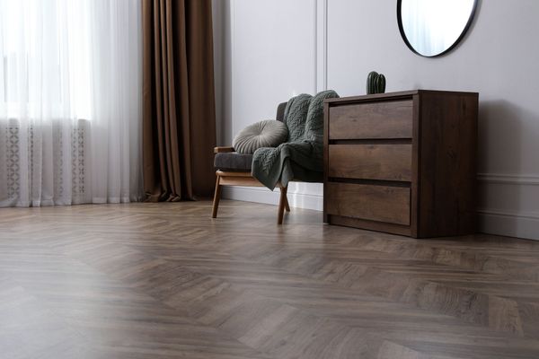 Il y a une chaise et une commode dans la chambre.