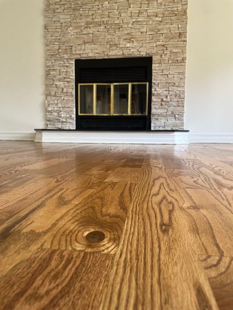 A living room with a fireplace and hardwood floors.