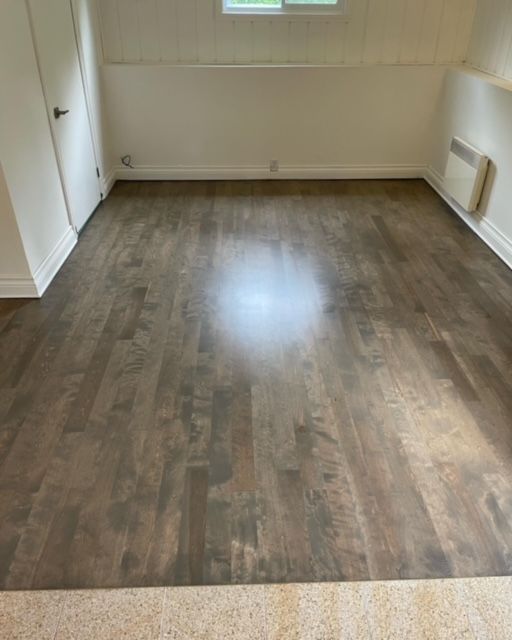 A room with a wooden floor and white walls.