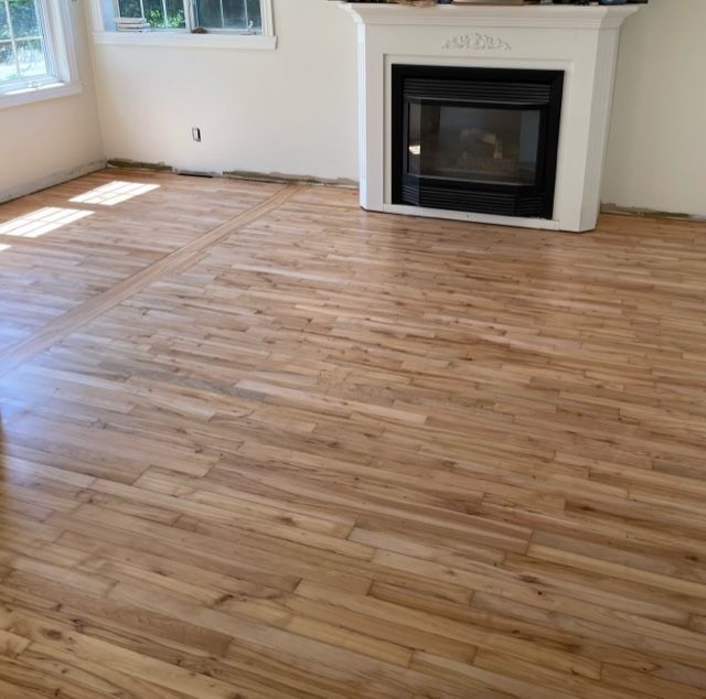 A living room with hardwood floors and a fireplace