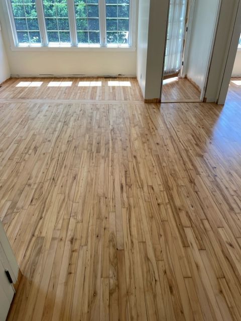 A living room with a wooden floor and a large window.