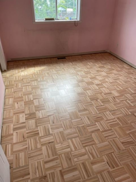 A room with a wooden floor and pink walls.