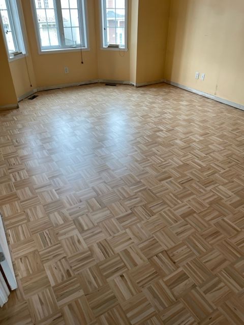 An empty room with a wooden floor and yellow walls
