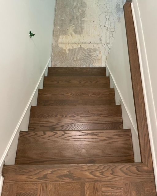 A set of wooden stairs leading up to a white wall